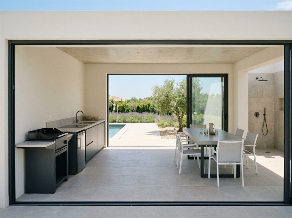 Intérieur d'un pool house contemporain avec cuisine, barbecue et douche à l'italienne, à Saint-Tropez (83)