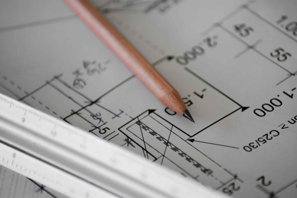 Plan d'architecte d'une extension de maison avec crayon et réglet, étude des cotes et démarches techniques