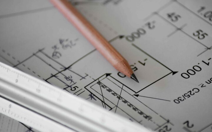 Plan d'architecte d'une extension de maison avec crayon et réglet, étude des cotes et démarches techniques